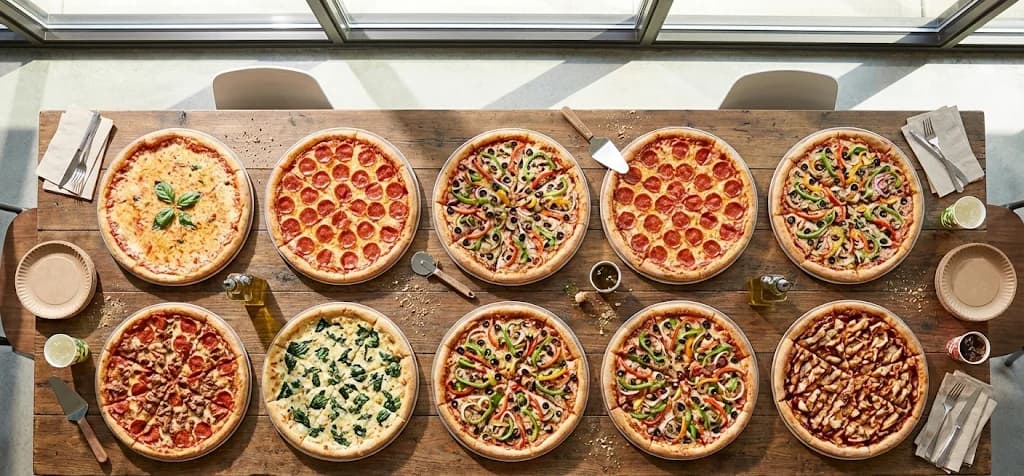 Large pizza party setup for 25 guests with variety of pizzas